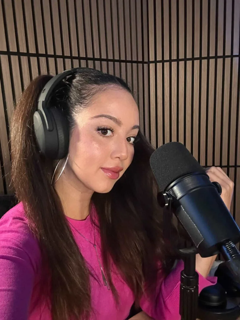 Jessica in headphones at a podcast microphone.