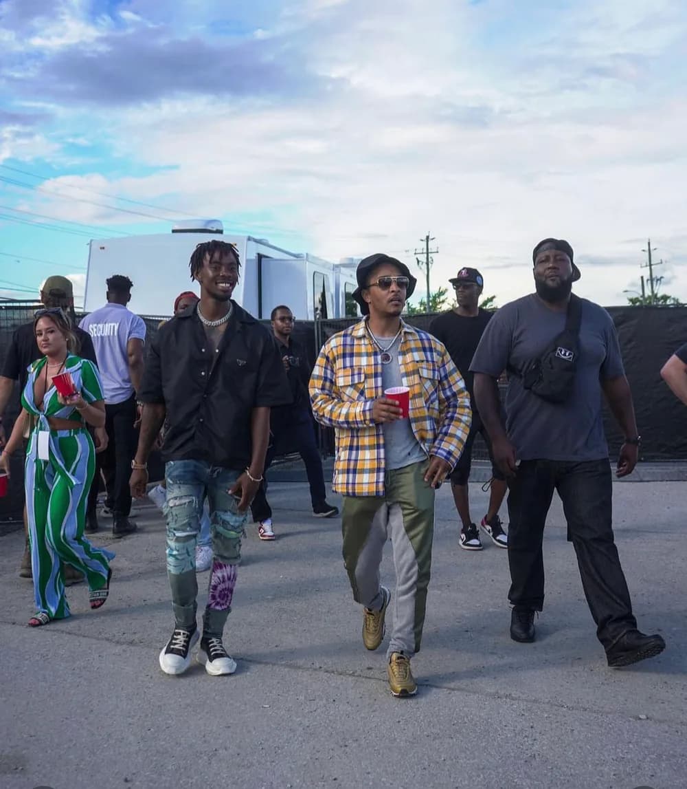 Kemdilo walking backstage beside T.I.