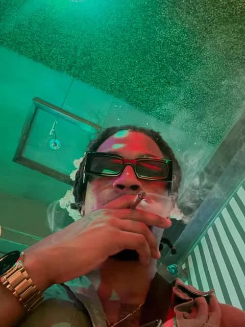 Cam in sunglasses under green light.